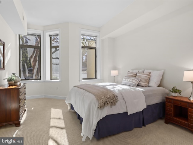 bedroom featuring baseboards and light carpet
