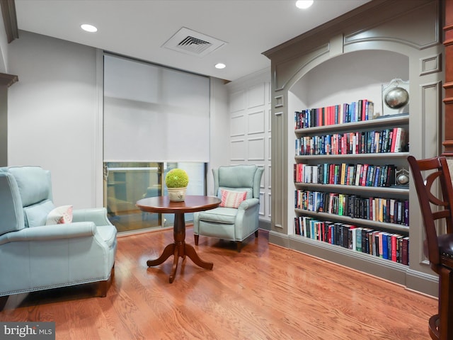 sitting room featuring built in shelves and light wood-type flooring