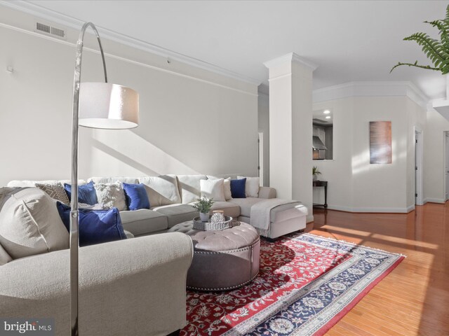 living room with crown molding and hardwood / wood-style floors