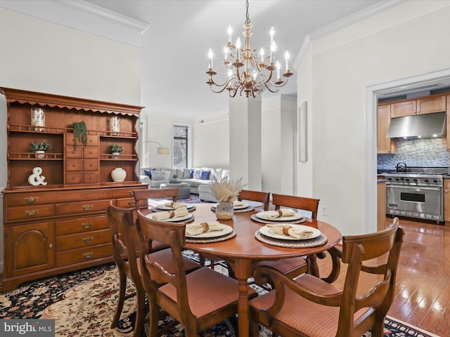 dining room featuring wood-type flooring, crown molding, and a chandelier