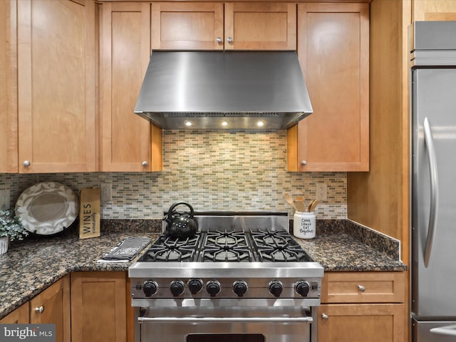 kitchen featuring decorative backsplash, stainless steel appliances, dark stone countertops, and exhaust hood