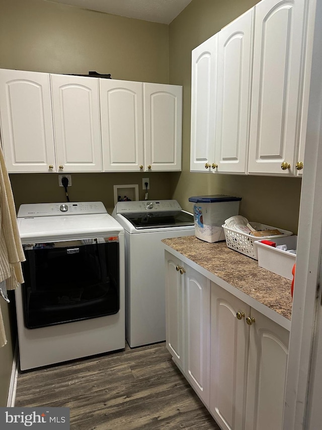 clothes washing area featuring washer and dryer, cabinets, and dark wood-type flooring