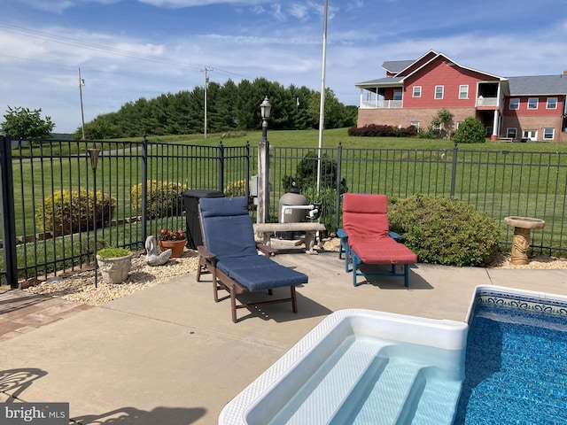 view of pool with a lawn and a patio