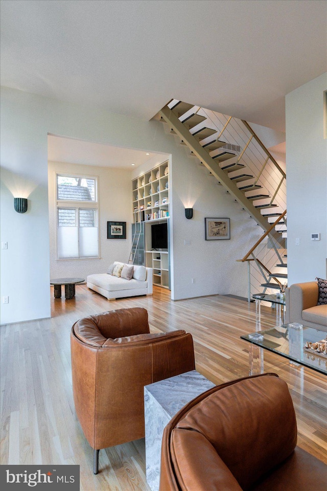 living area featuring wood finished floors and stairs