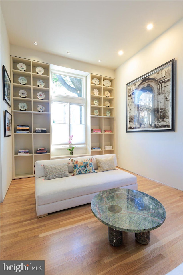 living area with built in shelves, recessed lighting, and wood finished floors