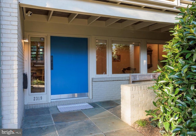 view of exterior entry with a patio