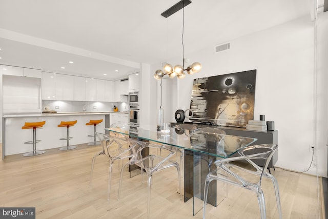 dining room featuring a chandelier and light hardwood / wood-style floors