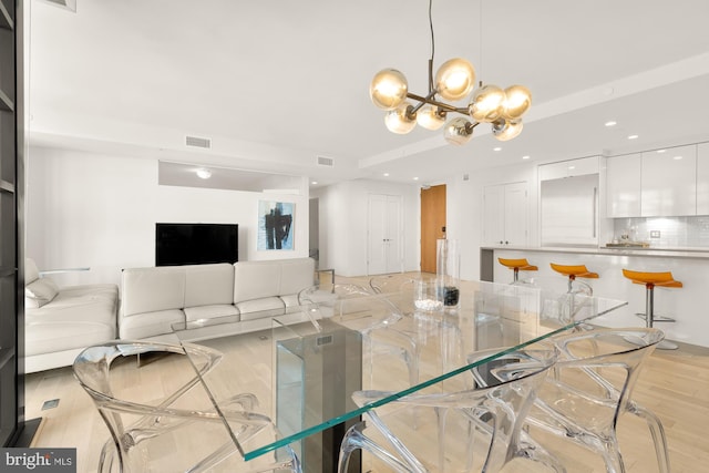 living room featuring light hardwood / wood-style flooring and an inviting chandelier