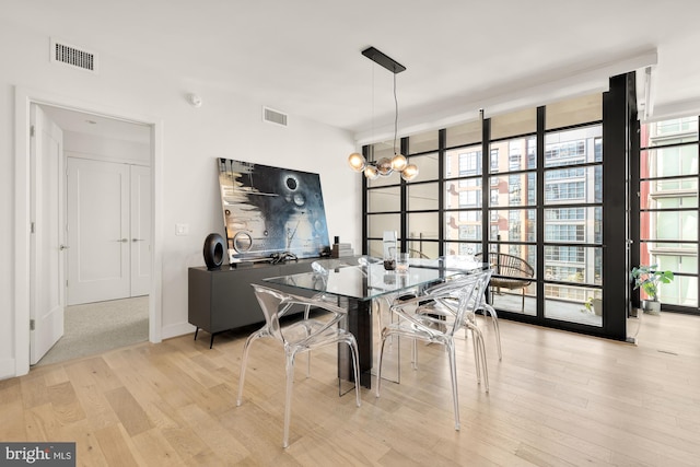 dining area with a notable chandelier and light wood-type flooring