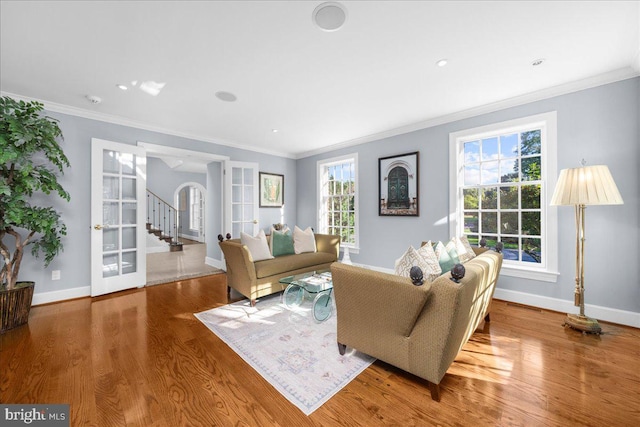 living room with crown molding, plenty of natural light, and hardwood / wood-style floors