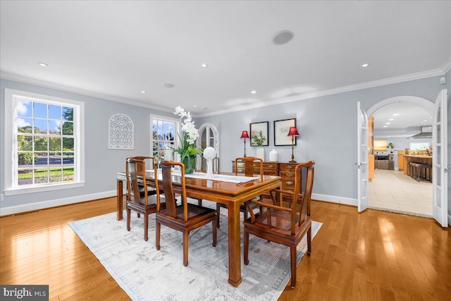 dining room featuring ornamental molding and light wood-type flooring