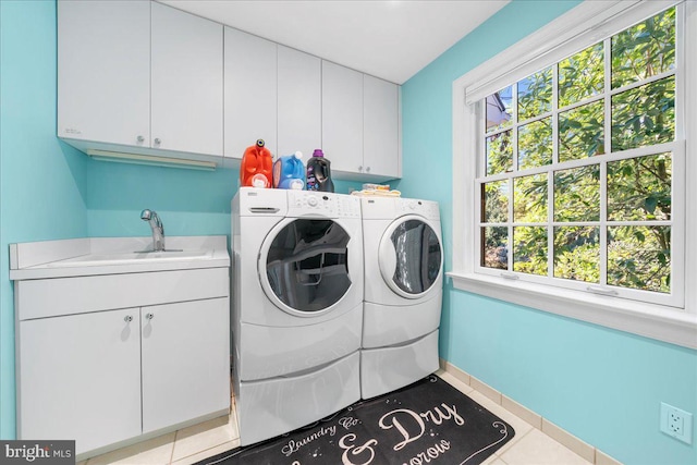 laundry area with cabinets, sink, washing machine and dryer, and a wealth of natural light