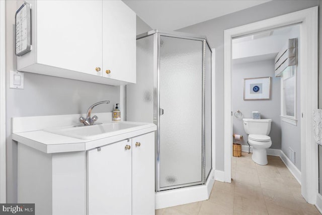 bathroom with vanity, toilet, a shower with shower door, and tile patterned flooring