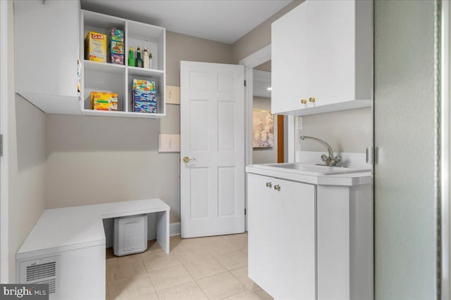 clothes washing area featuring sink and light tile patterned floors