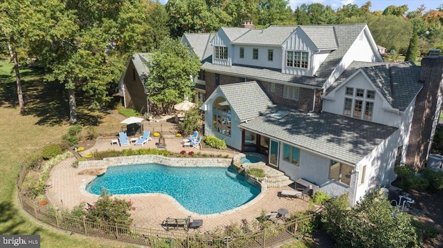 rear view of house with a patio area and a fenced in pool