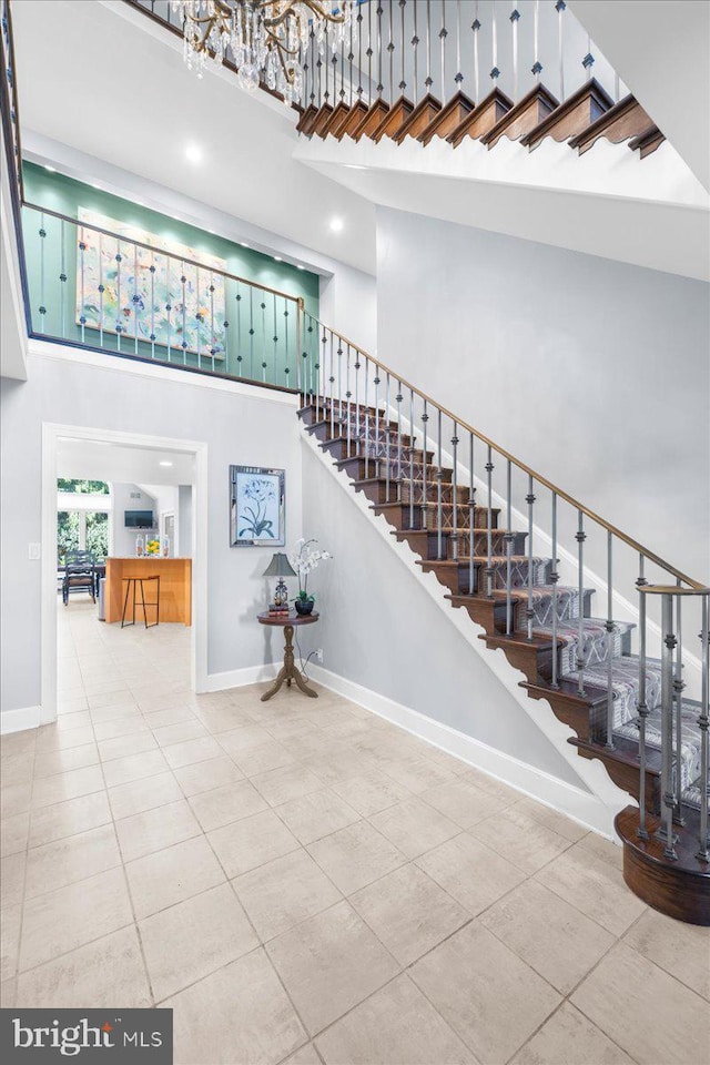 stairway with a high ceiling and tile patterned flooring