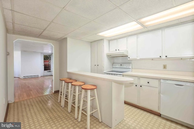 kitchen featuring backsplash, a kitchen breakfast bar, white cabinetry, light wood-type flooring, and white appliances