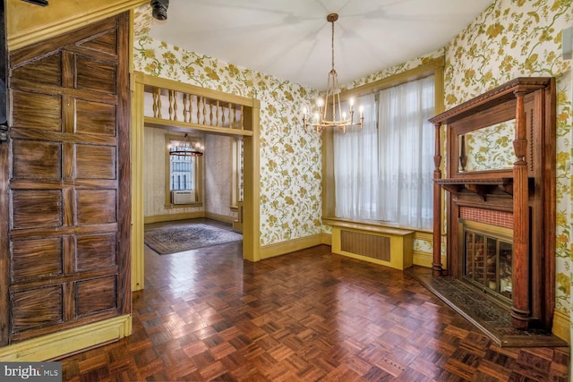 unfurnished dining area featuring a notable chandelier, a healthy amount of sunlight, dark parquet floors, and a fireplace