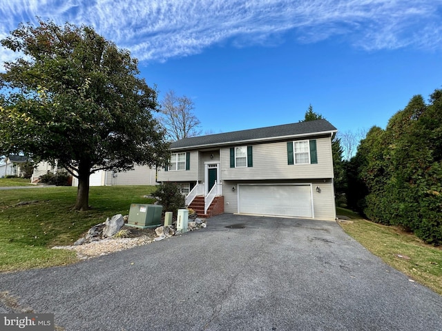 split foyer home with a garage and a front yard