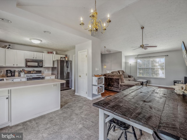 kitchen with white cabinetry, hanging light fixtures, a textured ceiling, and stainless steel appliances