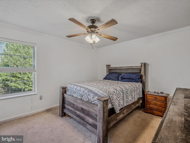 carpeted bedroom with a textured ceiling, ceiling fan, and crown molding