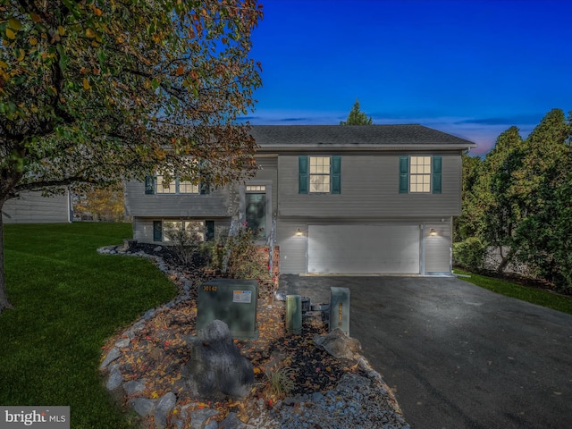 split foyer home with a garage and a yard