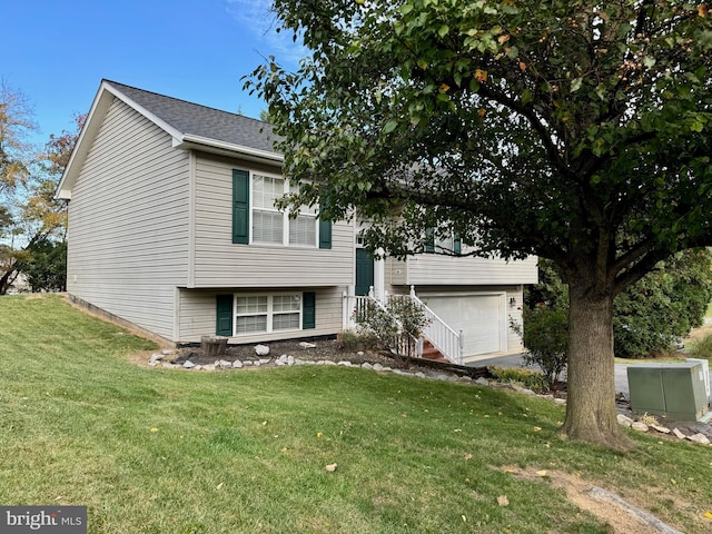 split foyer home featuring a garage and a front yard