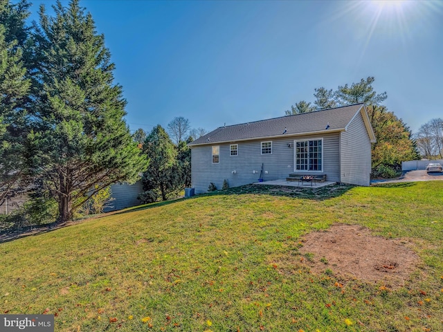 rear view of house featuring a lawn and a patio