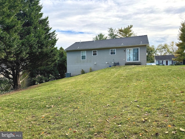 back of property with cooling unit and a yard