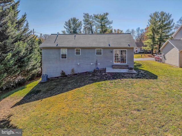 rear view of house featuring central air condition unit, a lawn, and a patio area