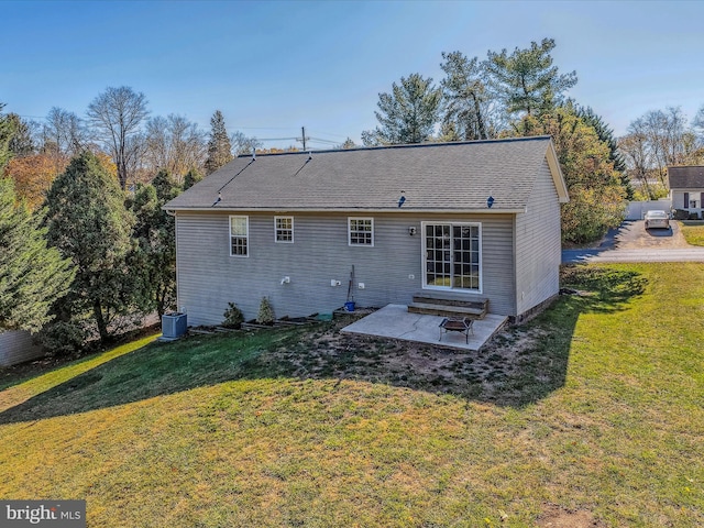 rear view of property with central AC unit, a patio, and a yard