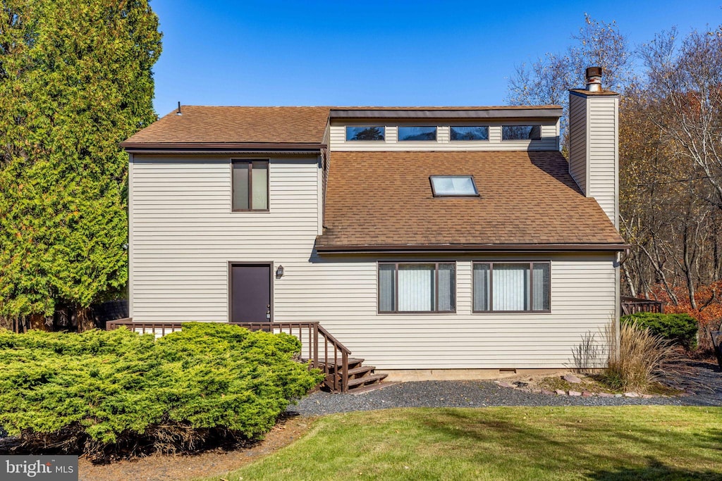 rear view of house featuring a yard