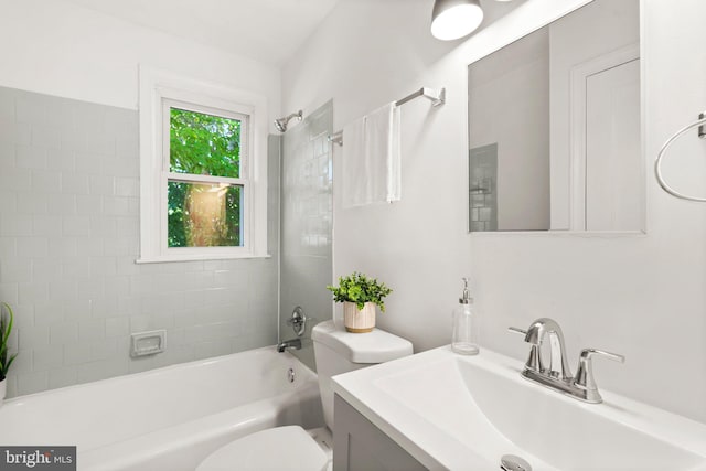 full bathroom featuring tiled shower / bath, vanity, and toilet