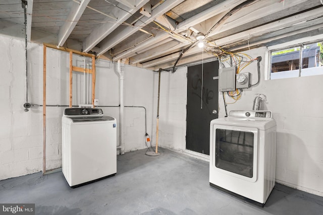 basement with electric panel and washing machine and dryer