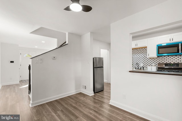 unfurnished living room with ceiling fan and hardwood / wood-style flooring