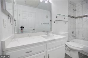 full bathroom featuring vanity, toilet, and tiled shower / bath