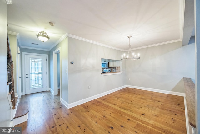 interior space with crown molding, hardwood / wood-style floors, and a chandelier