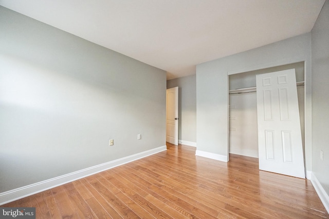 unfurnished bedroom with a closet and light hardwood / wood-style floors