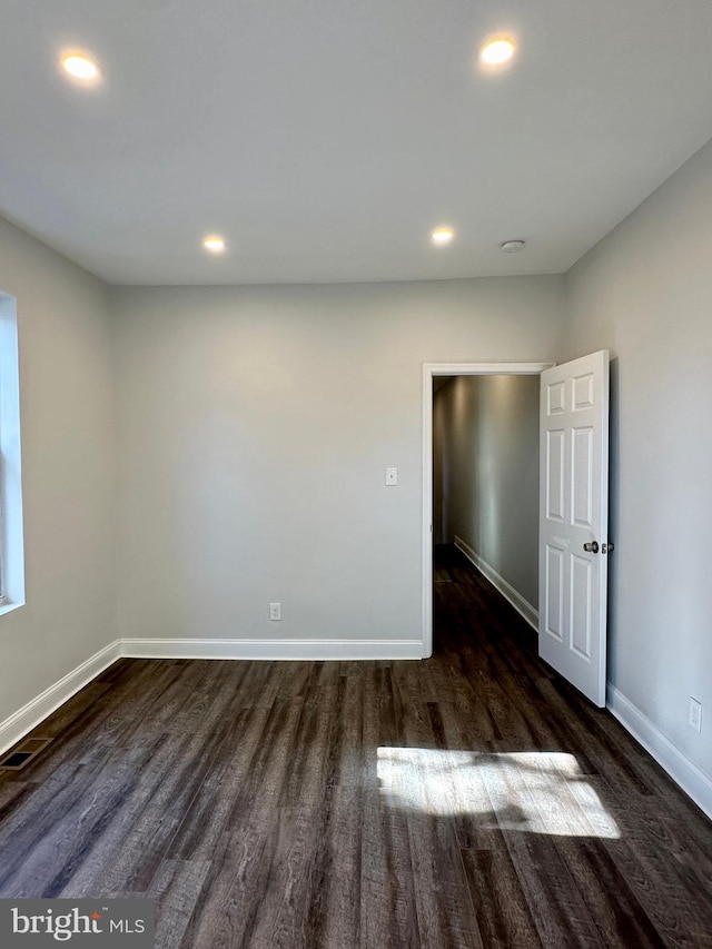 spare room with dark hardwood / wood-style flooring