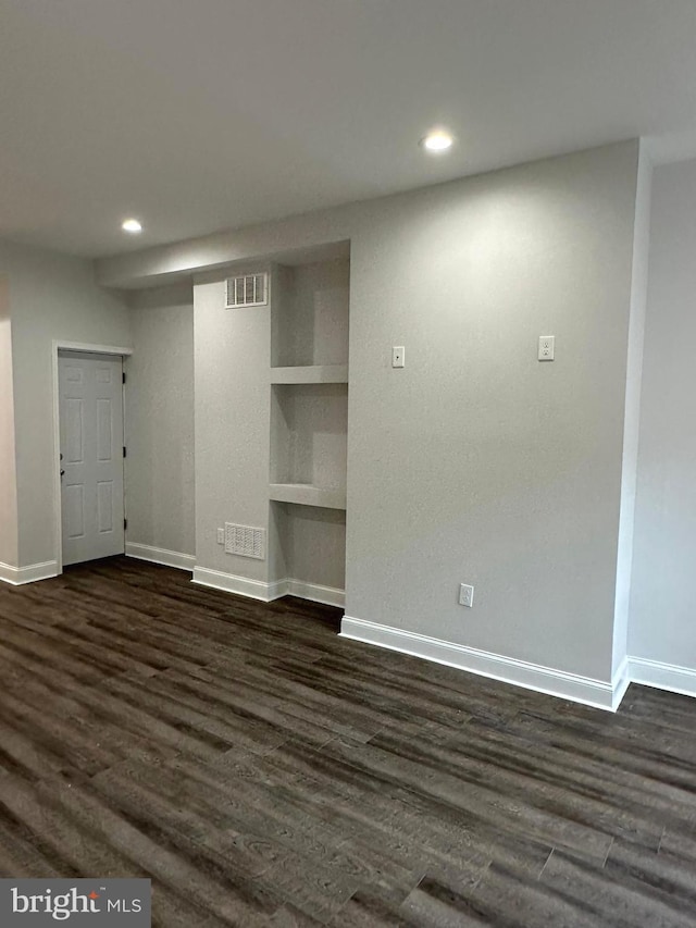 interior space with dark wood-type flooring and built in features