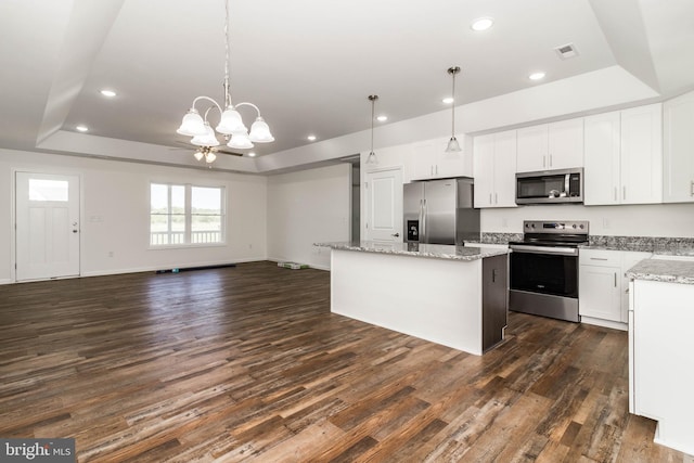 kitchen featuring white cabinets, stainless steel appliances, and a tray ceiling