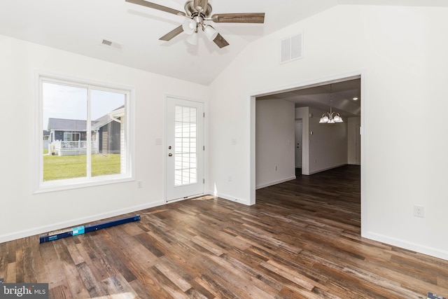 interior space featuring ceiling fan with notable chandelier, vaulted ceiling, and dark hardwood / wood-style flooring