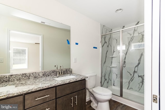 bathroom with a shower with door, vanity, hardwood / wood-style flooring, and toilet