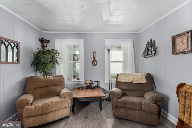 living area with hardwood / wood-style flooring and crown molding