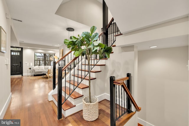 stairs featuring hardwood / wood-style floors