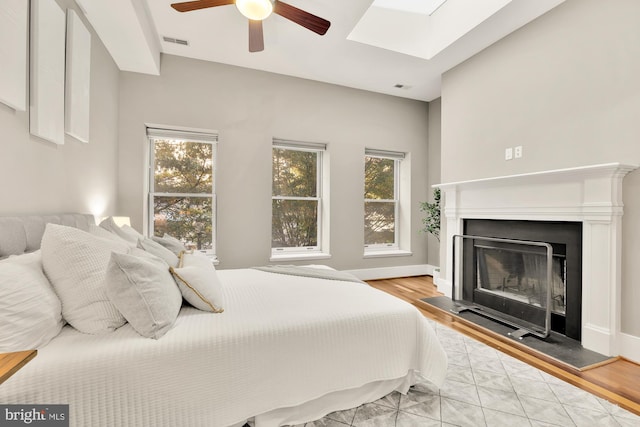 bedroom featuring light hardwood / wood-style flooring, multiple windows, and ceiling fan