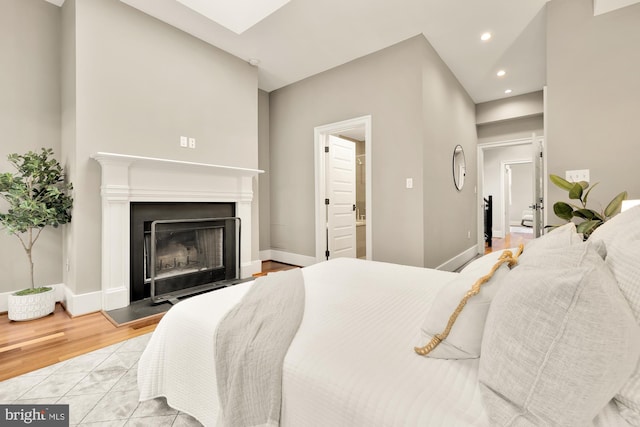 bedroom featuring light hardwood / wood-style flooring and ensuite bath