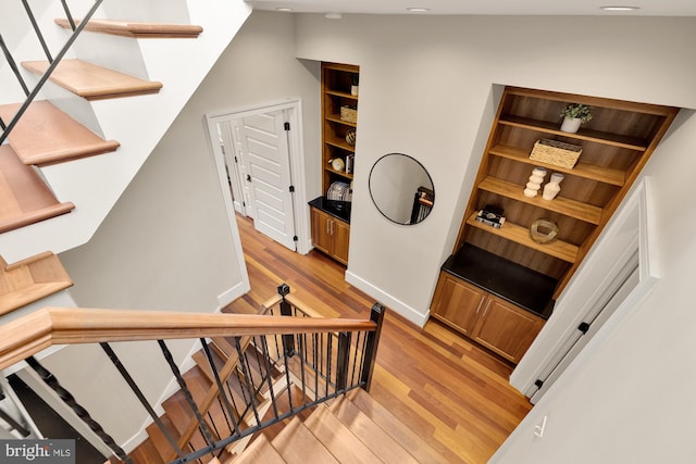 stairway featuring lofted ceiling and hardwood / wood-style floors