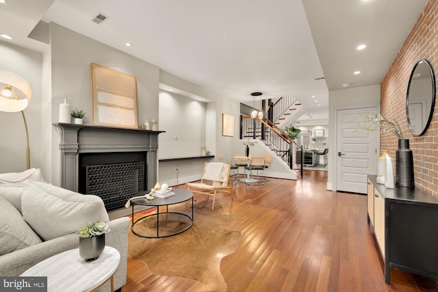 living room with brick wall and wood-type flooring