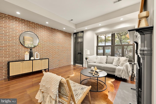 living room featuring light hardwood / wood-style floors and brick wall